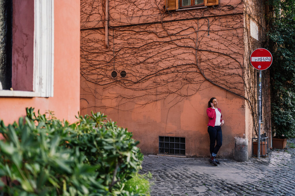 Dora Rossetti Traduttrice tecnica intenta a telefonare in piedi lungo una strada di Trastevere a Roma