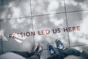 Sign on the pavement reading "Passion led us here"